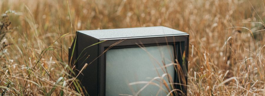 A CRT TV in a field looking for someone who takes old TVs