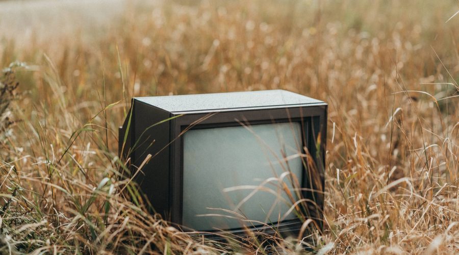 A CRT TV in a field looking for someone who takes old TVs